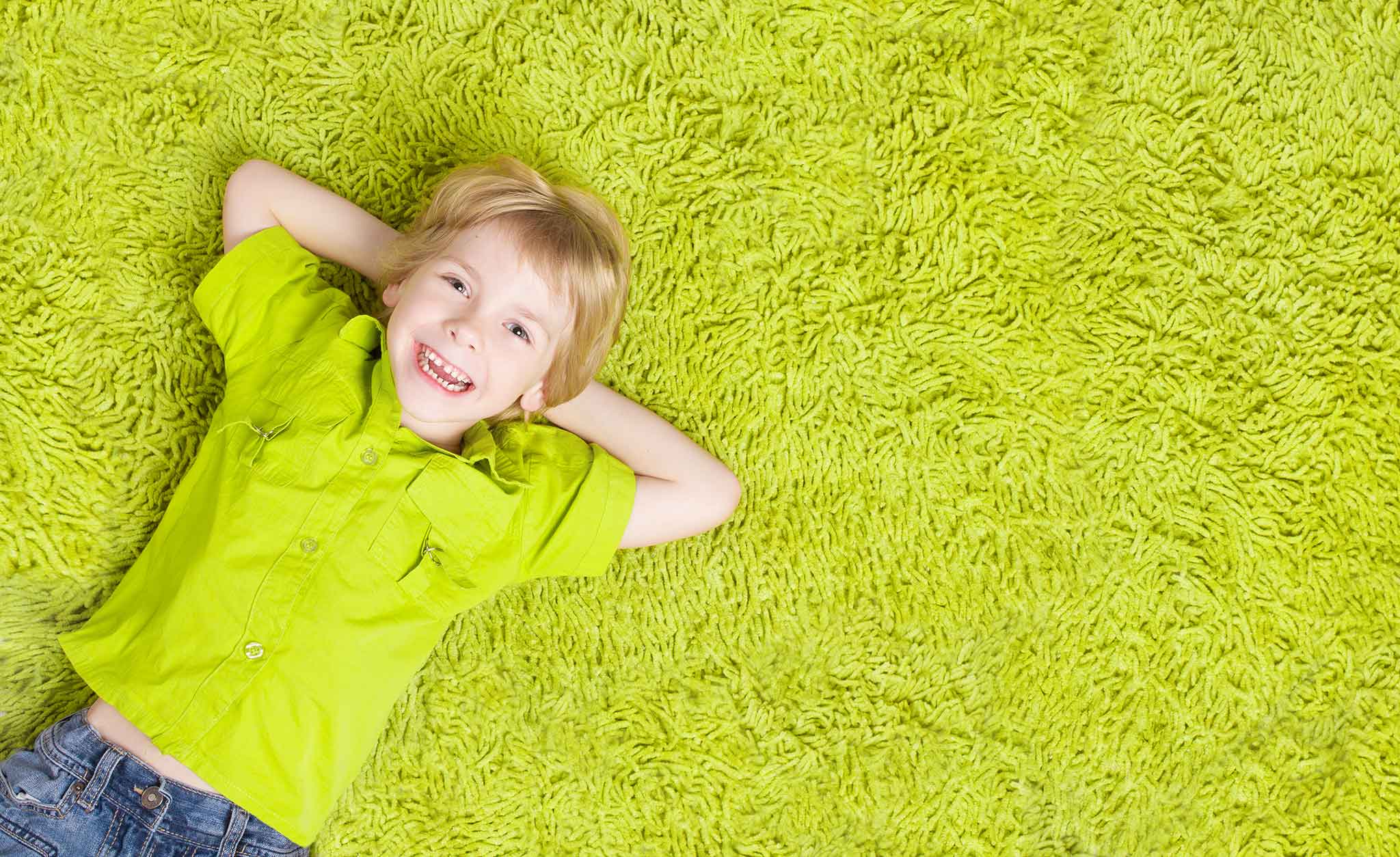 Happy baby smiling and laying on a rug